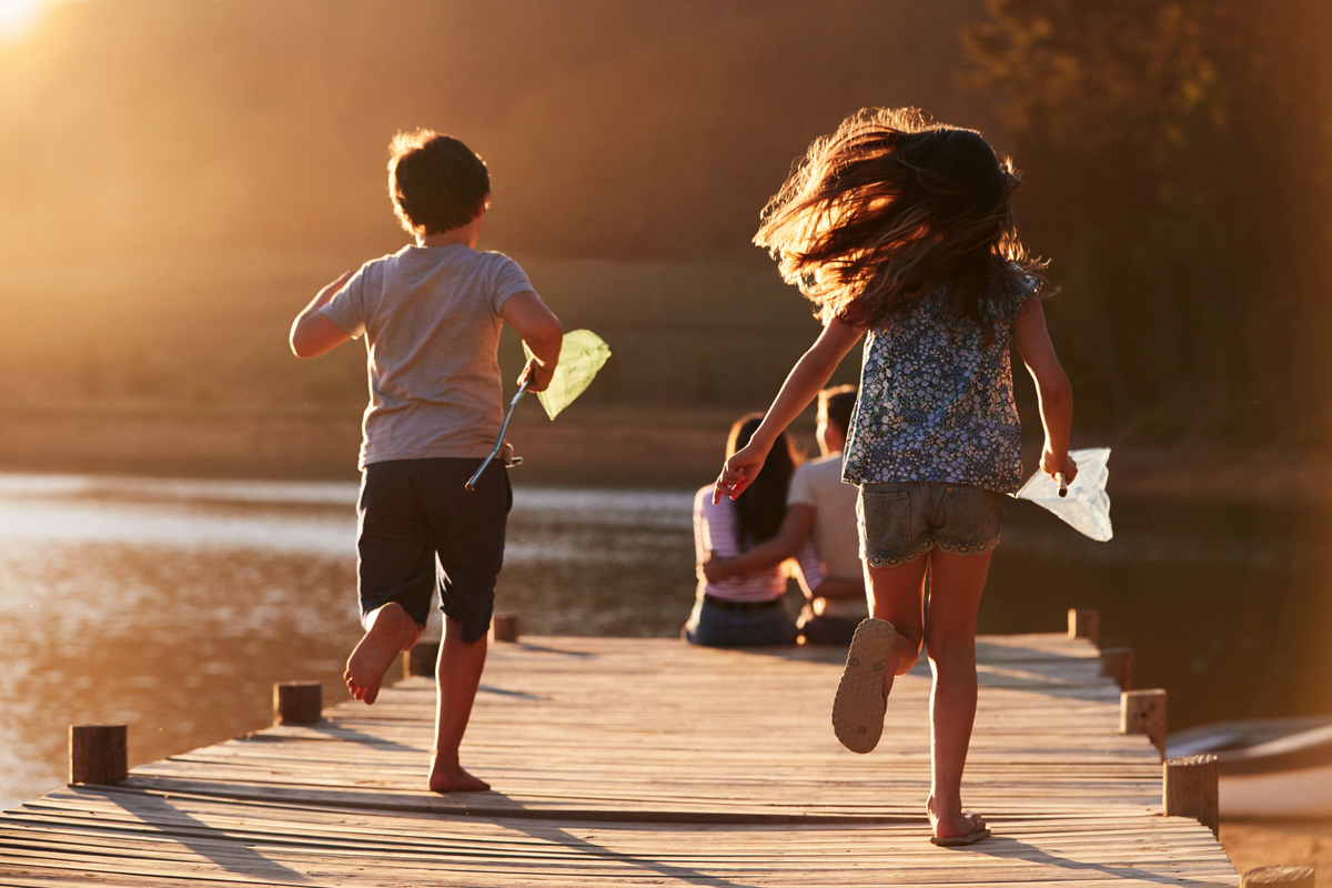 Kinder laufen auf hölzernen Steg am See auf Eltern zu - © Monkey Business - stock.adobe.com
