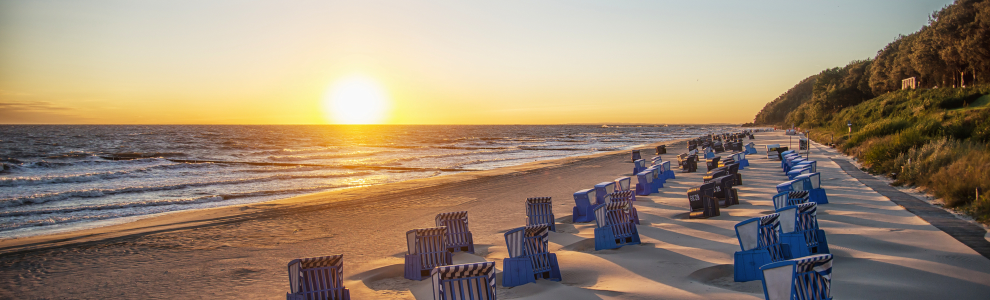 Schatten von Strankörben beim Sonnenaufgang am Strand von Usedom - © Patrick - stock.adobe.com