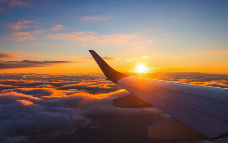 Flugzeugflügel im Sonnenuntergang - © ValentinValkov - stock.adobe.com