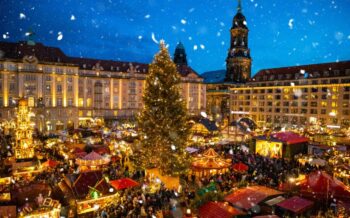 Festlich erleuchteter Striezlmarkt in Dresden mit großem Weihnachtsbaum und Schneefall – zauberhafte Flusskreuzfahrt im Advent