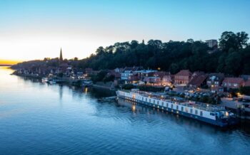 Die MS Thurgau Chopin liegt abends am Ufer eines historischen Städtchens – romantische Flusskreuzfahrt im Advent